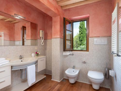 a bathroom with a sink and a toilet and a window at Villa La Veduta by Interhome in Grosseto