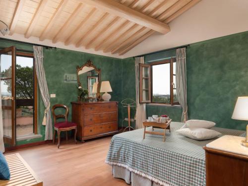 a bedroom with a bed and a dresser and a mirror at Villa La Veduta by Interhome in Grosseto