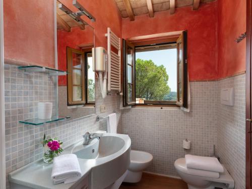 a bathroom with a sink and a toilet and a window at Villa La Veduta by Interhome in Grosseto