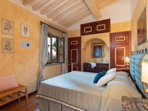 a bedroom with a bed and a chair and a window at Villa La Veduta by Interhome in Grosseto