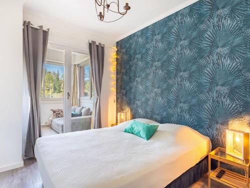 une chambre avec un grand lit avec un mur bleu dans l'établissement Apartment Mer et Soleil I-4 by Interhome, à Bormes-les-Mimosas