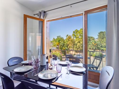 une salle à manger avec une table et des chaises et une grande fenêtre dans l'établissement Apartment Mer et Soleil I-4 by Interhome, à Bormes-les-Mimosas
