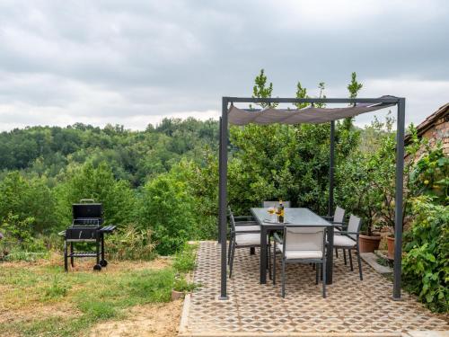 a patio with a table and chairs and a grill at Holiday Home Vallegra by Interhome in Cortiglione