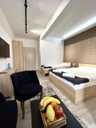 a bedroom with two beds and a bowl of fruit at Hotel FOCUS in Prilep