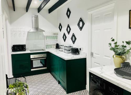 a kitchen with green cabinets and white walls at Paradise St Apartment Middle Floor 1 flight of stairs 3 bed 1 bathroom in Rhyl