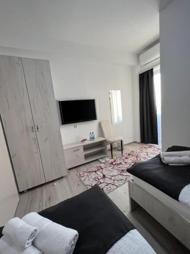 a white room with a bed and a flat screen tv at Hotel FOCUS in Prilep