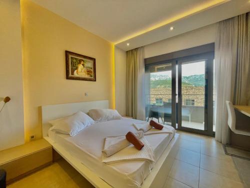 um quarto com uma cama e vista para uma varanda em Hotel Butua Residence em Budva