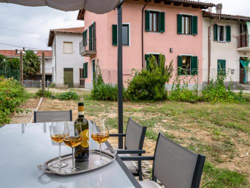 a table with a bottle of wine and glasses at Holiday Home Vallegra by Interhome in Cortiglione
