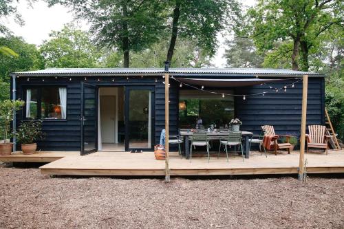 a blue tiny house with a table and chairs at De Buitenplek van Stek in Nunspeet