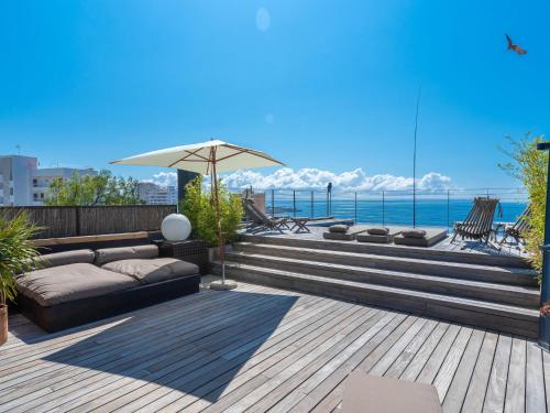 a patio with a couch and an umbrella and the ocean at Villa Vistamar by Interhome in Palma de Mallorca