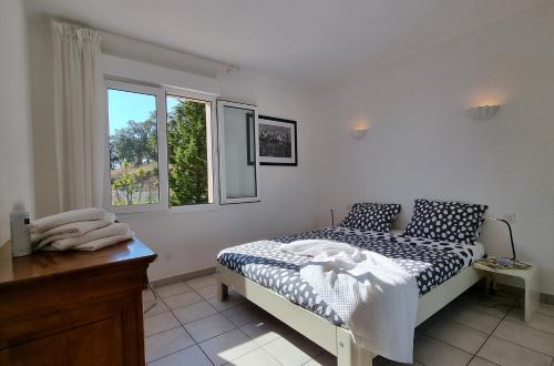 um quarto com uma cama e uma janela em La Belle Issambre em Roquebrune-sur-Argens