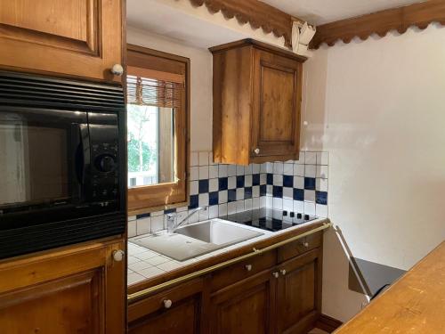 une cuisine avec un évier et un micro-ondes dans l'établissement Apartment Ginabelle 1-2 by Interhome, à Chamonix-Mont-Blanc