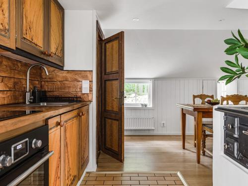a kitchen with wooden cabinets and a wooden floor at Chalet Jennys - B in JÃ¤mjÃ¶