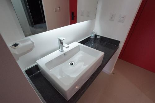 a bathroom with a white sink and a mirror at Zar San Luis Potosi in San Luis Potosí