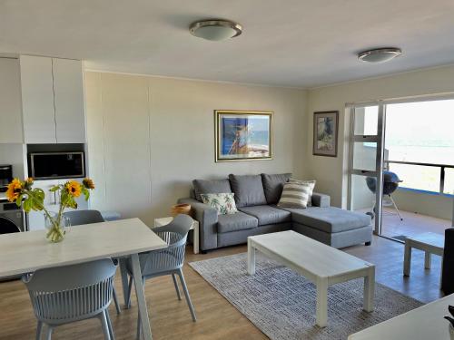 a living room with a couch and a table at Cape Town Beachfront Accommodation in Blouberg in Bloubergstrand