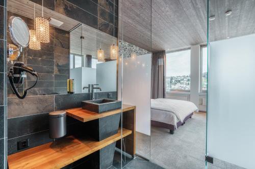 łazienka z umywalką i sypialnia w obiekcie b-smart hotel Menziken w mieście Menziken