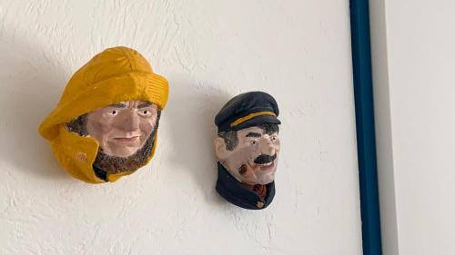 two masks of a man hanging on a wall at T3 - TERRASSE 30 m2 VUE OCEAN, 2 CHAMBRES, parking privatif et piscine en été in Lacanau-Océan