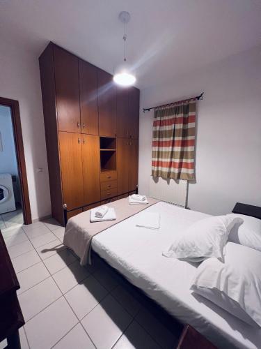 a bedroom with a large bed and a wooden cabinet at Four S Apartments in Mikonos