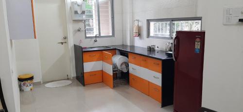 cocina con encimera negra y nevera en Chandralok Homestay, en Kolhapur