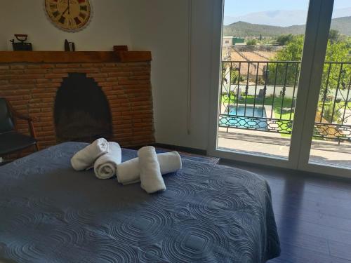 a bedroom with towels on a bed with a fireplace at "El Coberteras" in Cogollos de Guadix