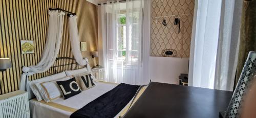 a bedroom with a bed and a table and a window at La Maison de Jardin in Lucca