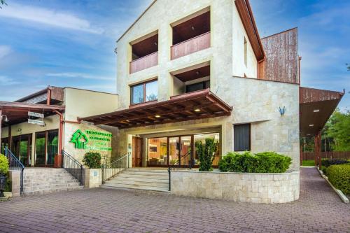 a building with a staircase in front of it at Erdőspuszta Club Hotel Fenyves in Debrecen