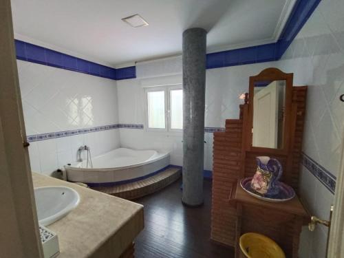 a bathroom with a tub and a sink and a bath tub at "El Coberteras" in Cogollos de Guadix