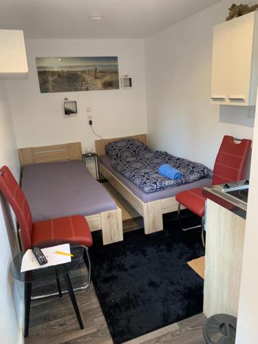 um pequeno quarto com uma cama, uma mesa e cadeiras em Tiny-Ferienwohnungen Hellerau em Dresden