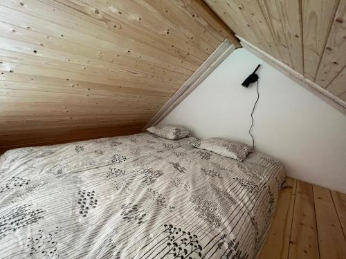 Cama en habitación pequeña con techo de madera en Kratikoda, en Rõõmu