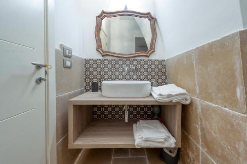 bagno con lavandino e specchio di Villa Minioti Apartment C ad Arnesano