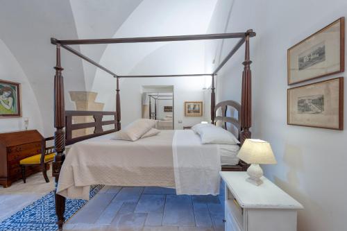 una camera con letto a baldacchino e tavolo di Villa Minioti Apartment C ad Arnesano