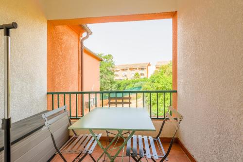 d'un balcon avec une table et un banc. dans l'établissement La Marine de Bravone, à Linguizzetta