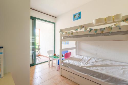 une chambre avec un lit superposé et un bureau dans l'établissement La Marine de Bravone, à Linguizzetta