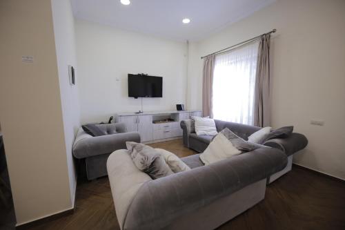 a living room with two couches and a flat screen tv at OXYGEN Shekvetili in Shekvetili