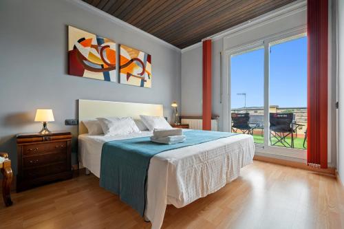 a bedroom with a bed and a large window at Ca la Francina in Torre del Español