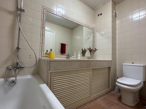 a bathroom with a sink and a toilet and a mirror at Golf and Beach Serenity in Aroeira
