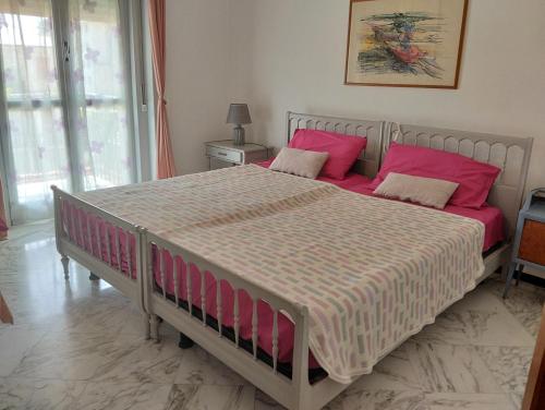 a bedroom with a large bed with pink pillows at Appartamento silenzioso comodo alle spiagge e stazione ferroviaria in Lavagna