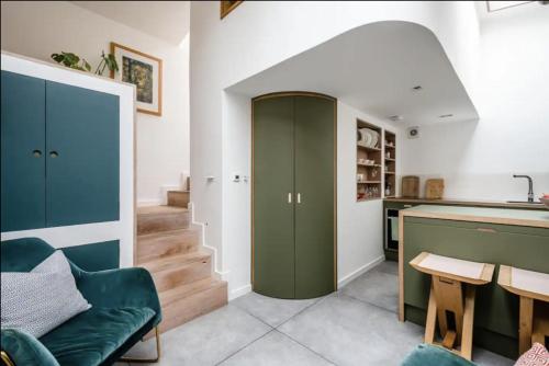 una sala de estar con un armario verde y una escalera en Entire Home on Victoria Park en Londres