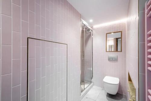a white bathroom with a toilet and a shower at Entire Home on Victoria Park in London