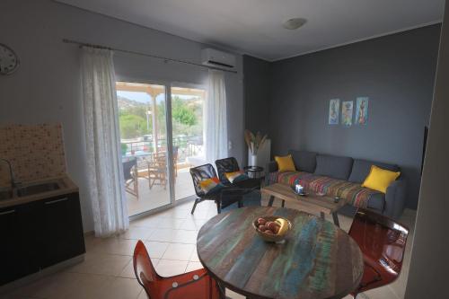 a living room with a table and a couch at House in riviera lagonisi in Kalívia Thorikoú