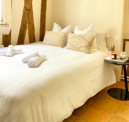 a large bed with white sheets and pillows on it at Appartement Paris rue Montorgueil in Paris