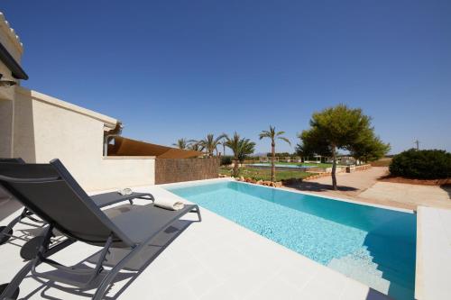 a chair sitting next to a swimming pool at Finca Cantó de Marina - Adults Only in Campos