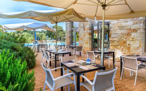 a patio with tables and chairs with umbrellas at Antico Podere San Francesco in Vada
