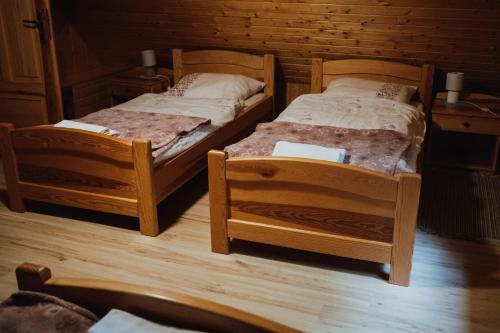 two twin beds in a room with wooden floors at Jasminowe Wzgorze in Wilkanów