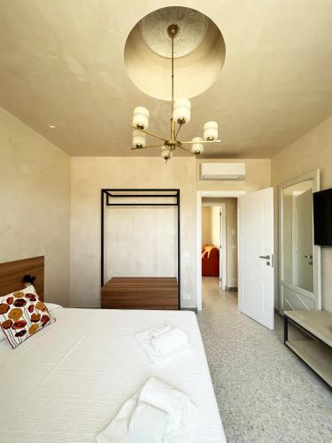 a bedroom with a large white bed and a chandelier at La casa di Irene - Suites con vista in Ragusa
