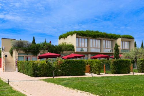 a building with a green roof with red umbrellas at Antico Podere San Francesco in Vada