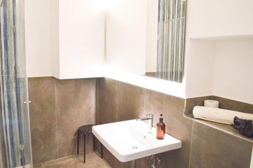 a bathroom with a sink and a mirror at Suite Comunicanti, tra Antico e Moderno in Assisi