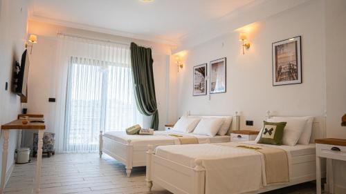 a bedroom with two beds and a large window at Maslin Butik Otel in Gokceada Town