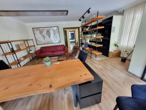 uma sala de estar com uma mesa e um sofá vermelho em tria house em Antalya