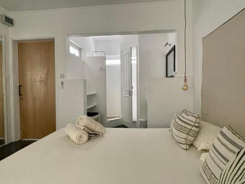 a bedroom with a white bed with towels on it at Cosy Guest House Sous le Badamier in Grand Baie